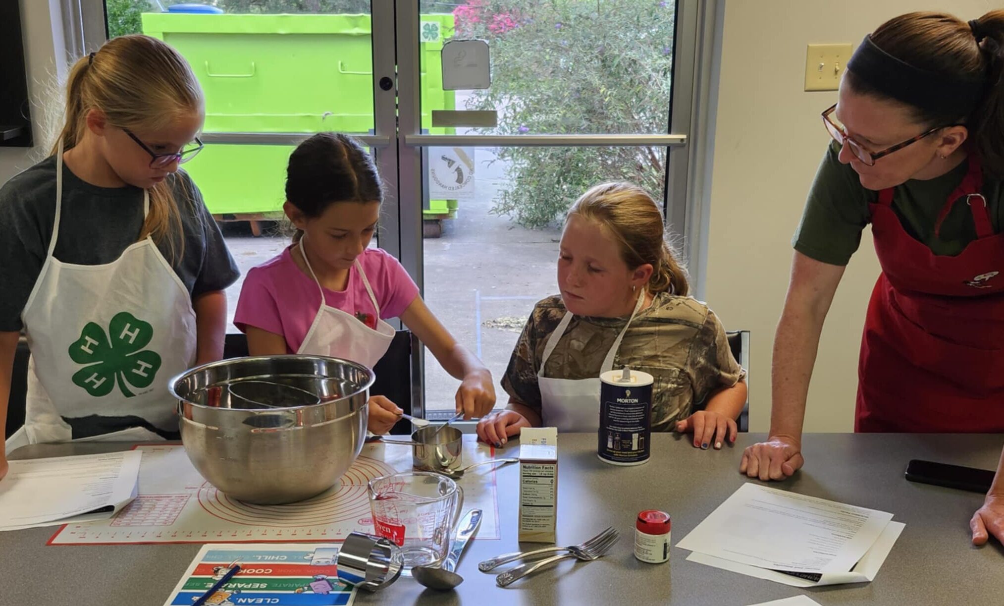 4-H youth measuring ingredients for a recipe.
